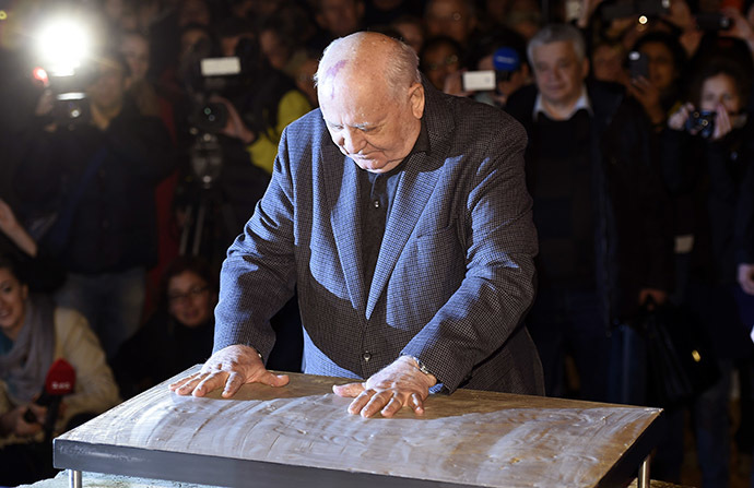 Foto : Ilustration The last ruling President of the Soviet Union Mikhail Gorbachev leaves his handprints in plaster cast bolted onto an original Wall piece from former Checkpoint Charlie border crossing on November 7, 2014 in Berlin. (AFP Photo/Odd Andersen)
